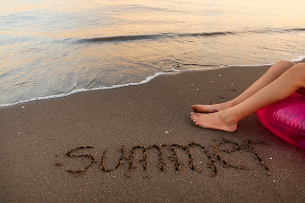 Photo gratuite vue du sable de la plage en été avec un message écrit dessus