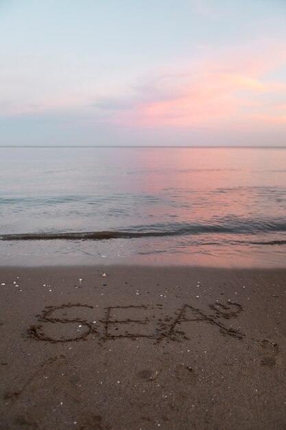 Vue du sable de la plage en été avec un message écrit dessus