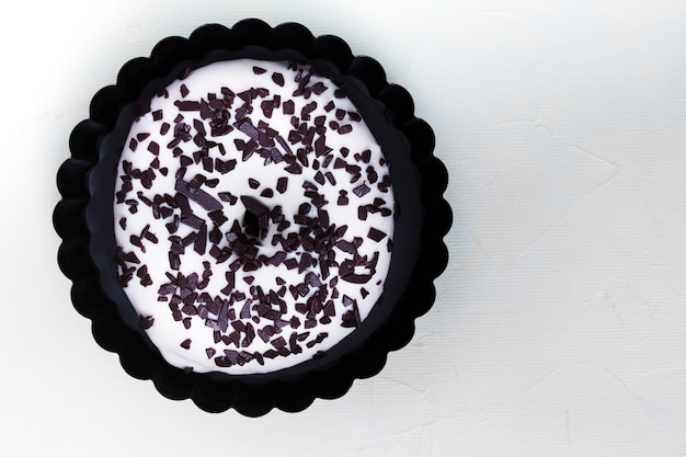 Une vue élevée de beignet blanc avec garnitures pépites de chocolat sur fond blanc