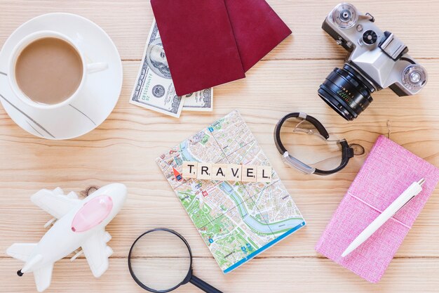 Vue élevée de divers accessoires de voyageur avec une tasse de thé sur une surface en bois