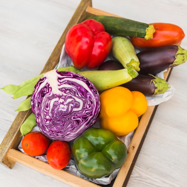 Vue élevée de divers légumes frais dans un récipient en bois