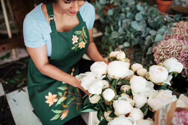 Vue élevée, de, femme, fleuriste, arranger, blanc, pivoine, fleurs, dans, magasin