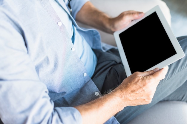 Photo gratuite vue élevée d'un homme senior tenant une tablette numérique