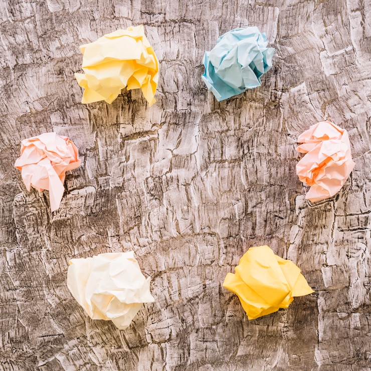 Photo gratuit vue élevée de papier froissé coloré sur fond en bois