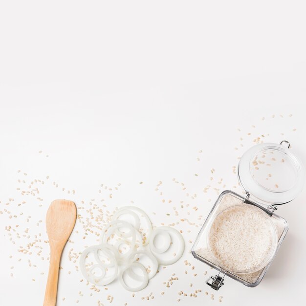 Vue élevée de la spatule; rondelles d&#39;oignon et pot de riz sur fond blanc