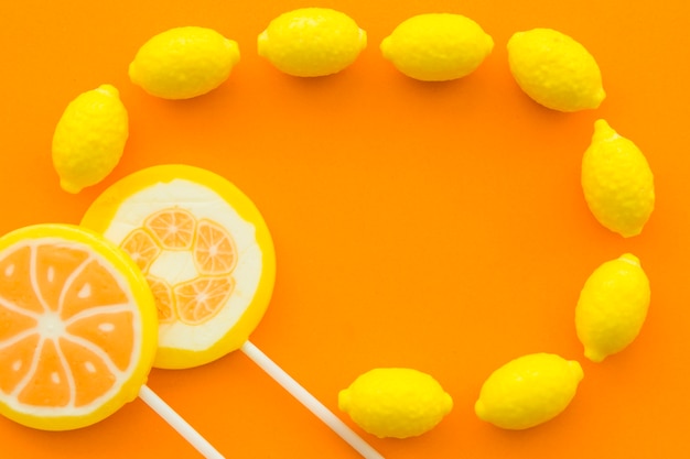 Photo gratuite vue élevée, de, sucettes citrus, et, bonbons citron, sur, orange, surface