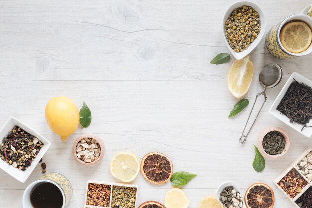 Vue élevée de thé au citron; herbes; passoire; fleurs de chrysanthème chinois séchées et pamplemousse séché