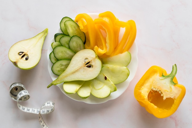 Vue élevée de tranches de légumes et de fruits avec mesure