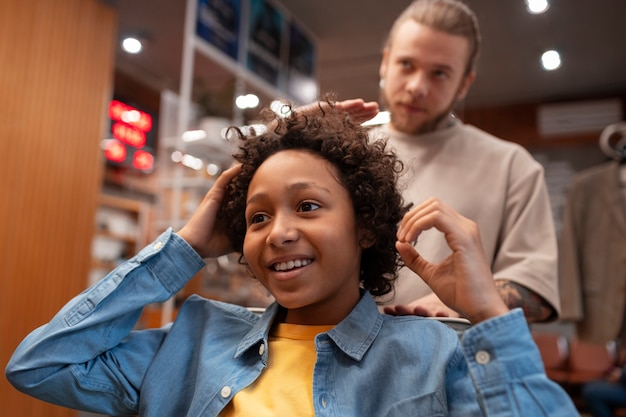 Photo gratuite vue d'enfant au salon de coiffure