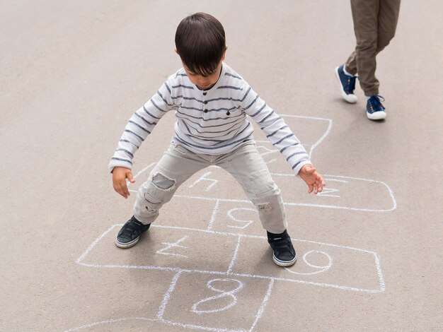 Vue d'enfant jouant à la marelle