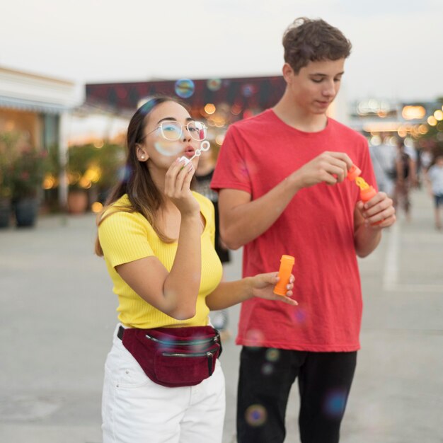 Vue de face adolescents soufflant des bulles