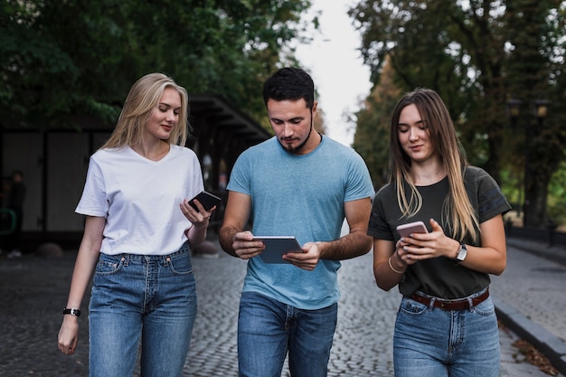 Vue de face des adolescents vérifiant leurs téléphones