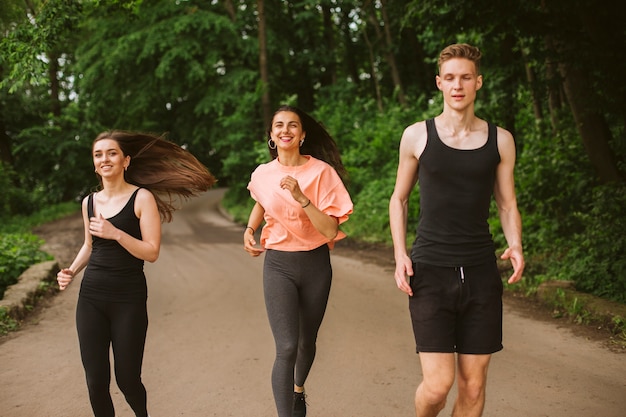 Photo gratuite vue de face amis courir dans la nature