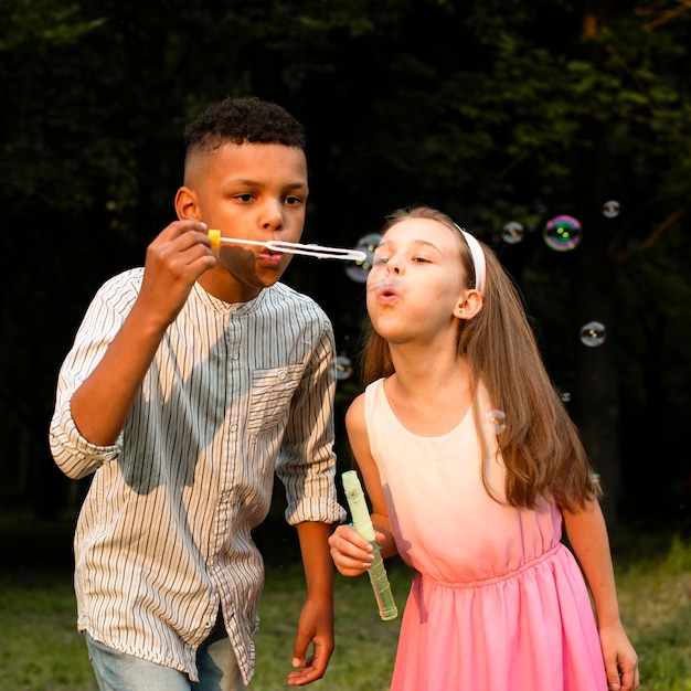 Photo gratuite vue de face d'amis faisant des bulles de savon