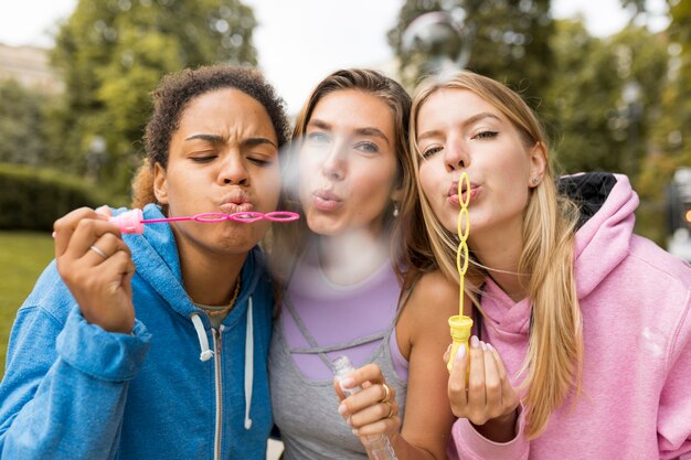 Vue de face amis faisant des bulles de savon