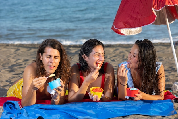 Vue de face amis heureux au bord de la mer