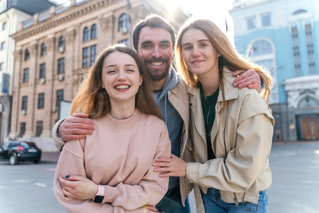 Vue de face d'amis smiley à l'extérieur dans la ville posant ensemble