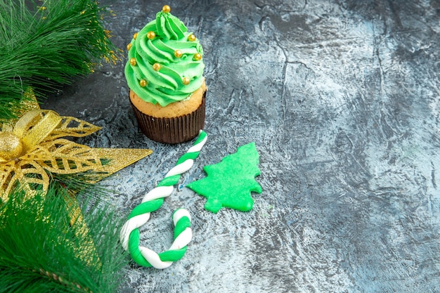 Vue de face arbre de noël cupcake noël bonbons ornements de noël sur fond gris avec espace de copie