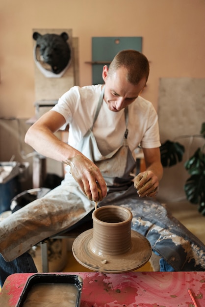 Vue de face artisan faisant de la poterie en studio
