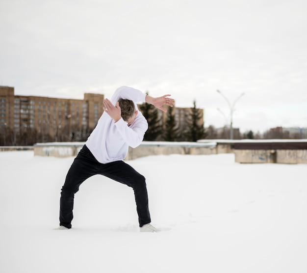 Photo gratuite vue de face de l'artiste hip hop masculin posant dans la neige