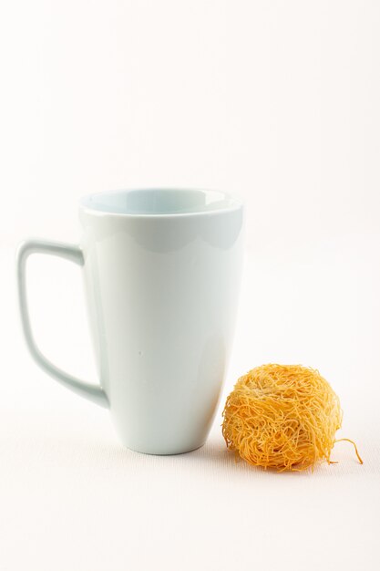 Une vue de face autour de délicieux gâteau sucré savoureux rond formé cuire au four avec tasse blanche isolée