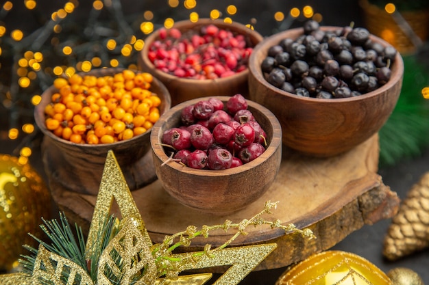 Vue de face de baies fraîches sur fond sombre photo couleur de fruits goût frais moelleux sauvage beaucoup de noël