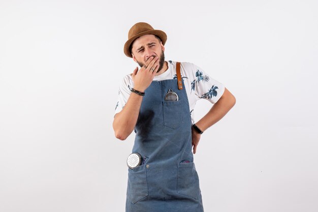 Vue de face barman mâle bâillant et fatigué du travail sur le mur blanc club travail de nuit alcool bar boisson