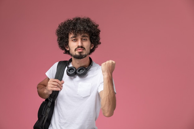 Vue de face beau mec serrant sa main avec casque et sac