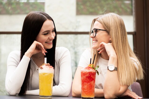 Vue de face de beaux amis prenant un cocktail