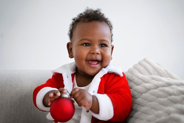 Vue de face bébé souriant portant une tenue de père noël