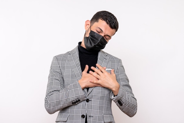 Vue de face bel homme en costume mettant les mains sur la poitrine debout sur fond blanc isolé