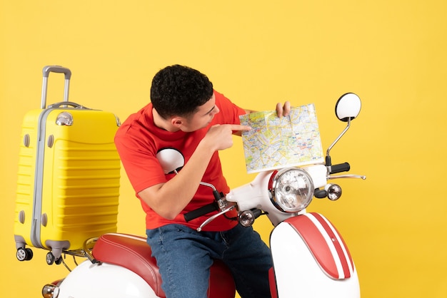 Vue de face bel homme sur cyclomoteur en regardant la carte