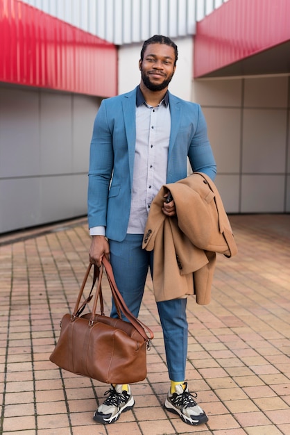 Vue de face bel homme tenant son sac