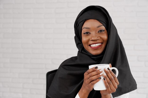 Vue de face de la belle femme en hijab noir posant