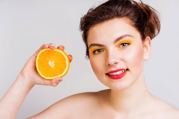 Vue de face de la belle femme à l'orange