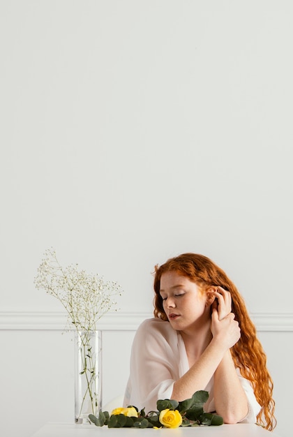 Photo gratuite vue de face de la belle femme posant avec des fleurs de printemps et de l'espace de copie