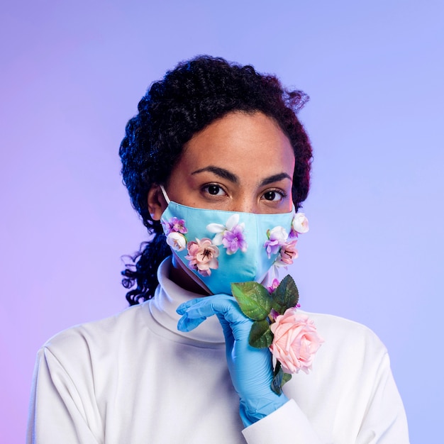 Photo gratuite vue de face de la belle femme posant avec des gants floraux et un masque