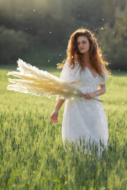 Vue de face belle femme posant avec des plantes