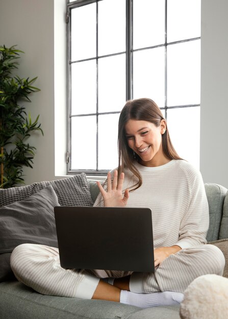 Vue de face de la belle femme restant sur ordinateur portable