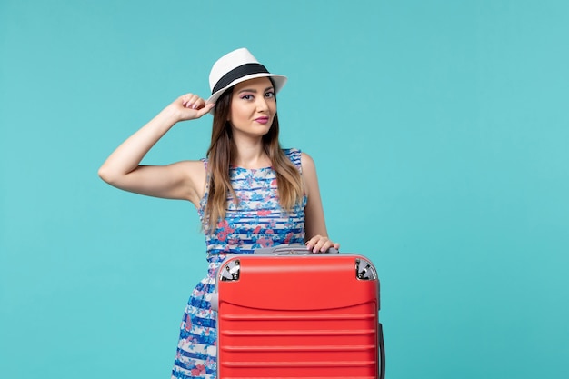 Vue de face belle femme se préparant pour les vacances et posant sur un espace bleu clair