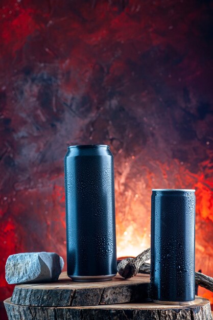 Vue de face boisson énergisante en canettes sur l'obscurité de l'alcool de boisson rouge