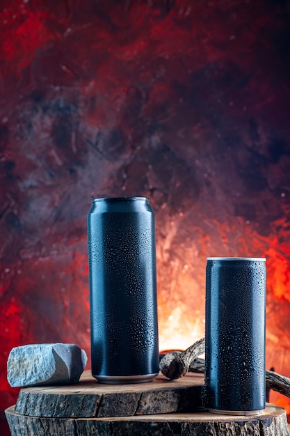 Vue de face boisson énergisante en canettes sur l'obscurité de l'alcool de boisson rouge