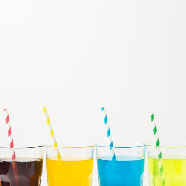 Vue de face des boissons gazeuses dans des verres avec des pailles et de l'espace de copie