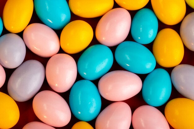 Une vue de face bonbons multicolores bon-bon sucré savoureux sur le tissu rouge fond sombre confiserie biscuits douceur