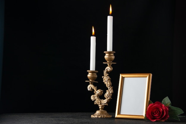 Vue de face des bougies allumées avec cadre photo sur une surface sombre