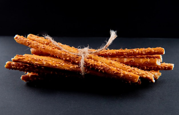 Vue de face bouquet de baguettes de pain sur fond noir