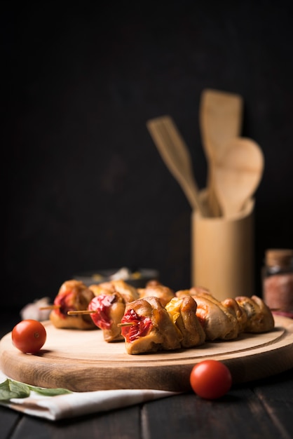 Vue de face brochettes sur planche de bois avec tomates