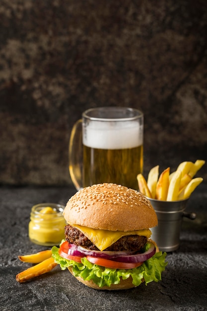 Vue de face burger de boeuf, frites et sauce avec de la bière et copie-espace