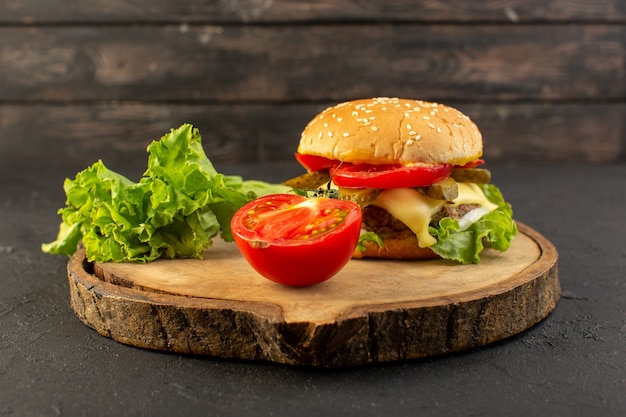 Une vue de face burger de poulet avec fromage et salade verte avec tomate sur le bureau en bois et sandwich restauration rapide