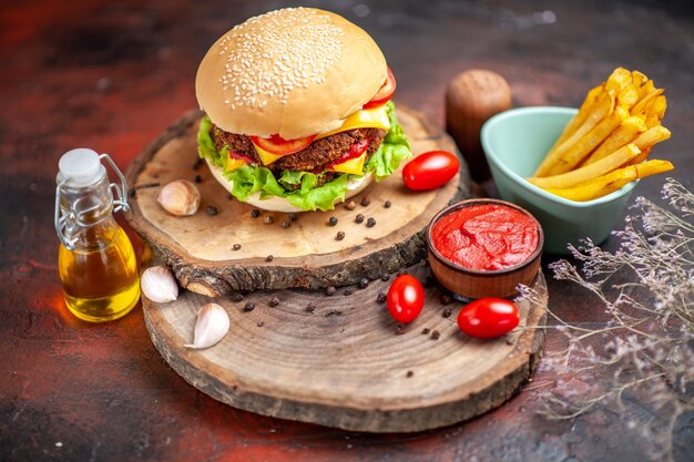 Vue de face burger de viande avec des frites sur le fond sombre